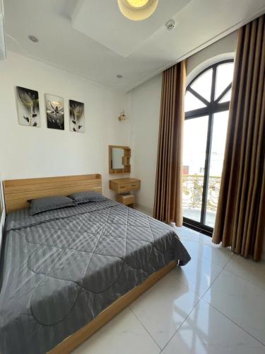 a bedroom with a bed and a large window at Lya Homestay CMT8 Da Nang in Danang