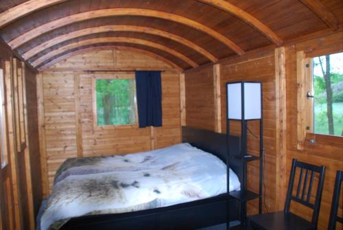 ein Zimmer mit einem Bett in einer Holzhütte in der Unterkunft Alpacacamp in Helvécia