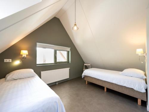 two beds in a room with a attic at Aan Noordzee Villa Veranda huisdier toegestaan max 2 in Sint Maartensvlotbrug