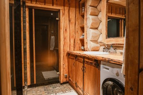 a bathroom with a sink and a washing machine at Metskapteni Puhkemaja in Põõsaspea