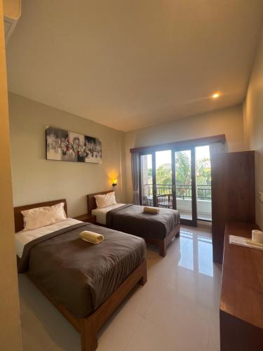 a hotel room with two beds and a balcony at 21REDA Cozy Stay in Uluwatu