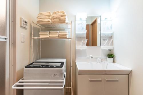 a small kitchen with a refrigerator and a sink at 楓 和室の一棟貸切 最大10名宿泊可能 駅徒歩2分 関西空港直通 in Osaka