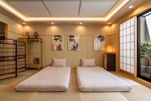 two beds in a room with a ceiling at 楓 和室の一棟貸切 最大10名宿泊可能 駅徒歩2分 関西空港直通 in Osaka