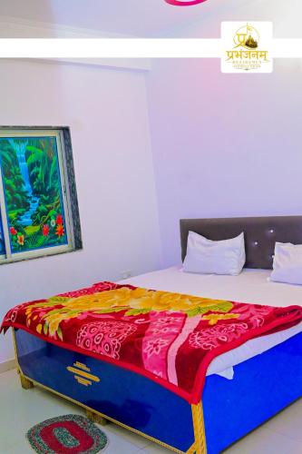 a bedroom with a bed with a colorful blanket on it at Prabhanjanam Residency in Ayodhya