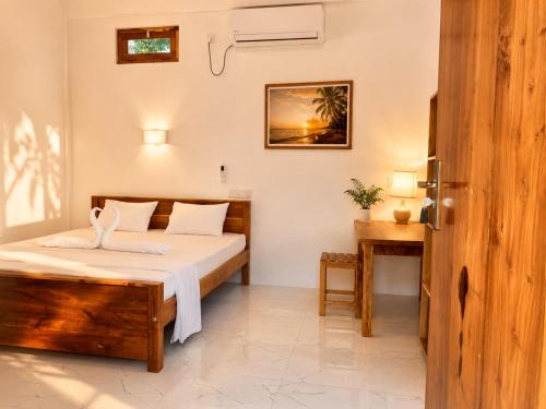 a bedroom with a bed and a desk in a room at Royal Palms Resort in Arugam Bay