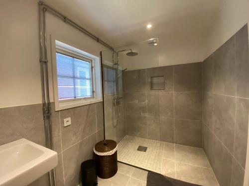 ein Badezimmer mit Dusche und Waschbecken in der Unterkunft Magical hide-away in the forest in Trensum