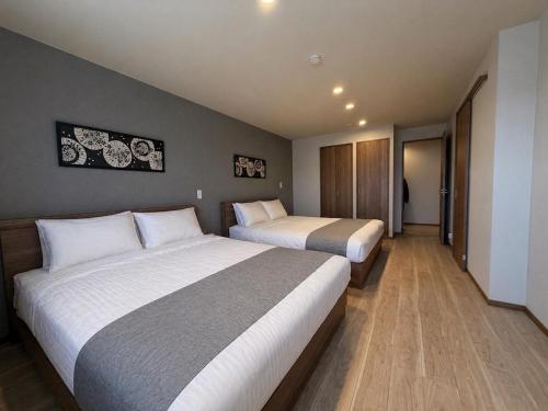 two beds in a hotel room with two beds at Fubuki Kimobetsu in Abuta