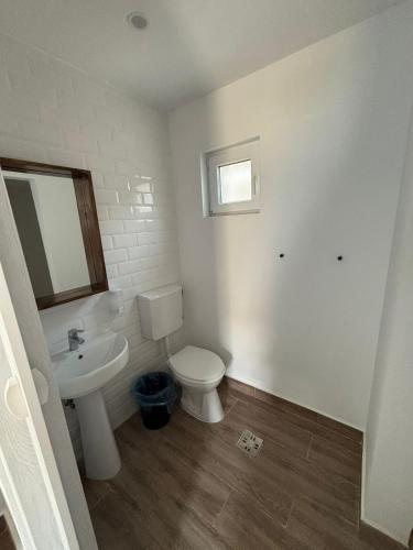 a bathroom with a white toilet and a sink at Casa Maria in Vama Veche