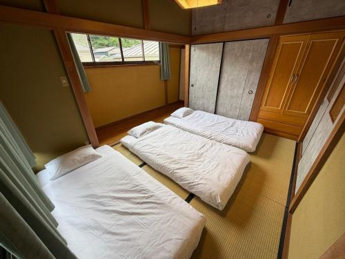 two beds in the corner of a room at Knot Kyonan in Katsuyama