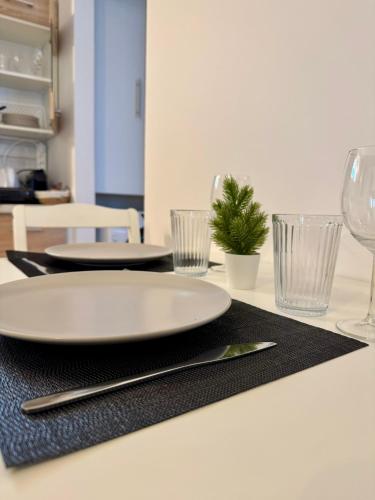 a table with two white plates and glasses on it at Lemon Tree Residence in Artemida