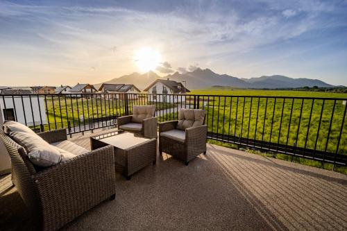 a balcony with chairs and a table and a view at LomniSki apartment in Veľká Lomnica