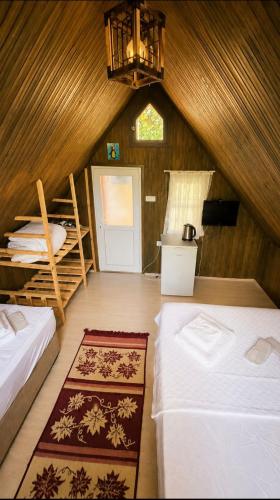 a attic room with two beds and a window at Cirali Camping in Cıralı