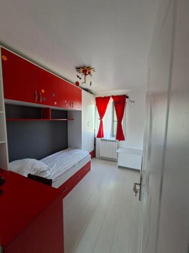 a bedroom with a bed with red cabinets and a window at Exclusiv new family in Năvodari