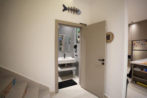 a bathroom with a sink and a mirror and a staircase at Blooms Villa in Al Rama