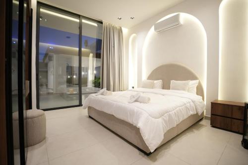 a bedroom with a large bed and a large window at Blooms Villa in Al Rama