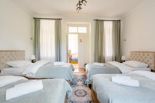 a room with four beds with white pillows at Nazy's Guest House in Joqolo