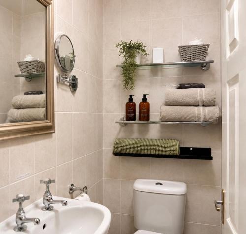 a bathroom with a sink and a toilet and a mirror at The Wadham in Weymouth