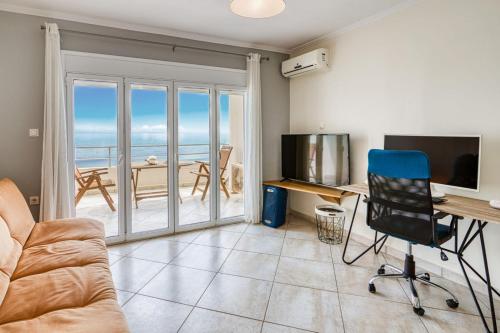 a living room with a couch and a desk with a computer at Komi Shoreline Blue Window in Kómi