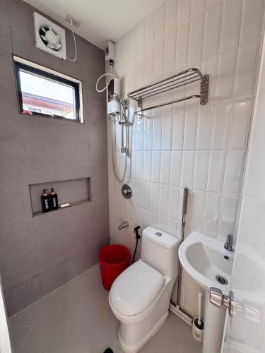 a white bathroom with a toilet and a sink at Idesia Lipa Custodio Suites in Lipa