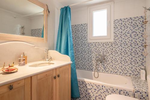a bathroom with a sink and a tub and a shower at Tinos Sunset House in Tinos