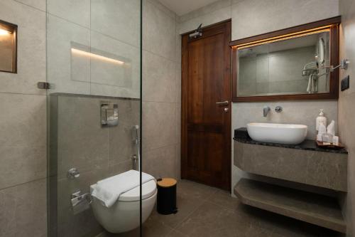 a bathroom with a shower and a toilet and a sink at Sanskreti in Cochin
