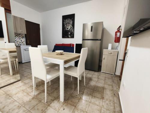 a kitchen with a table and chairs and a refrigerator at baia verde holiday in Baia Verde