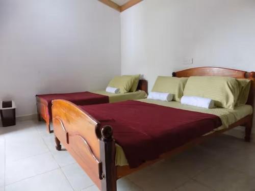 two twin beds in a room with at Sajee Residence Nilaveli in Trincomalee