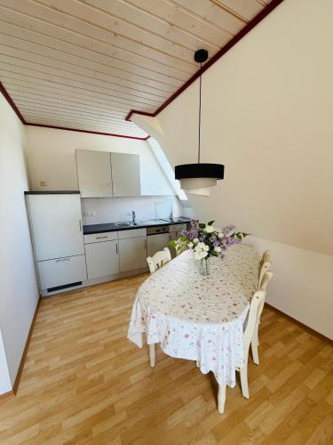 a dining room with a table with flowers on it at Irseer Hof in Hagnau in Hagnau