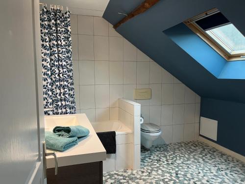 a blue bathroom with a sink and a toilet at Le Miel des Muses in Brive-la-Gaillarde