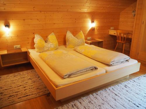 a bedroom with two beds in a wooden room at Haus Kanisfluh in Au im Bregenzerwald