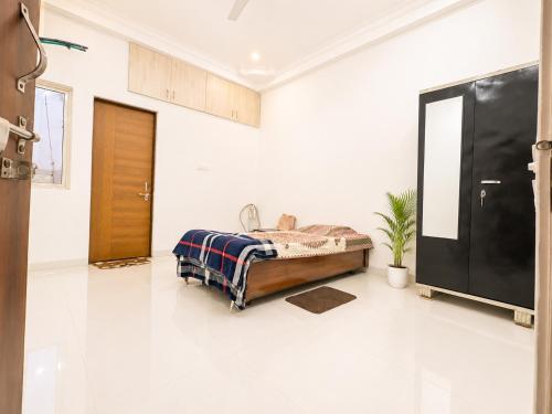 a bedroom with a bed and a tv in a room at Kesarionstay in Indore