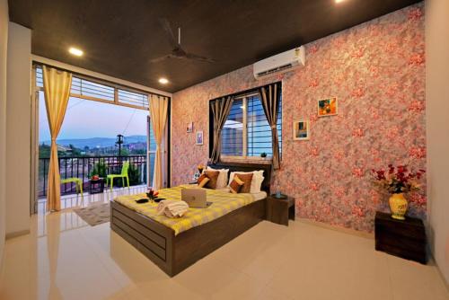 a bedroom with a bed with a laptop on it at I EMPYREAN STAYS ll MYSTICAL STONE VILLA ll 4BHK II AC II PRIVATE POOL II in Lonavala