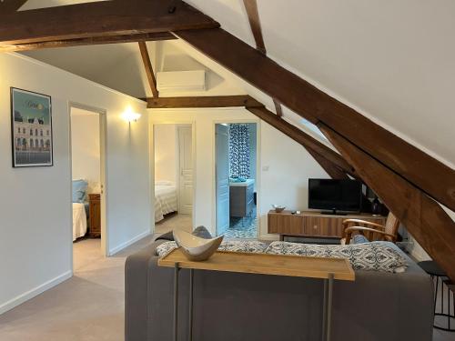 a living room with a couch and a tv at Le Miel des Muses in Brive-la-Gaillarde