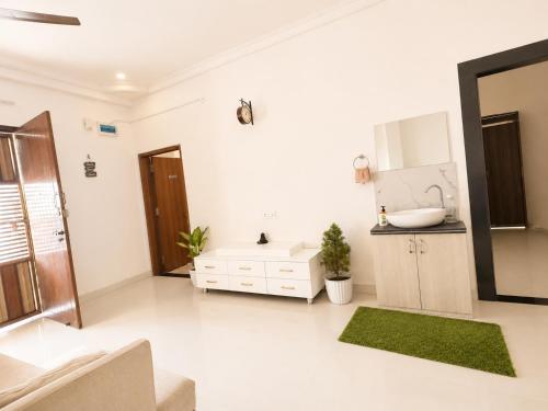 a white bathroom with a sink and a tub at Kesarionstay in Indore