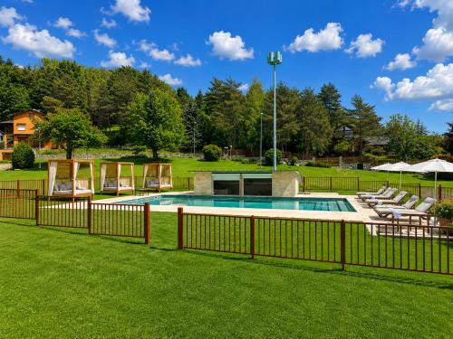 a fence around a pool in a yard at ELS OCELLS Apartaments i Cases Rurals in Camprodon