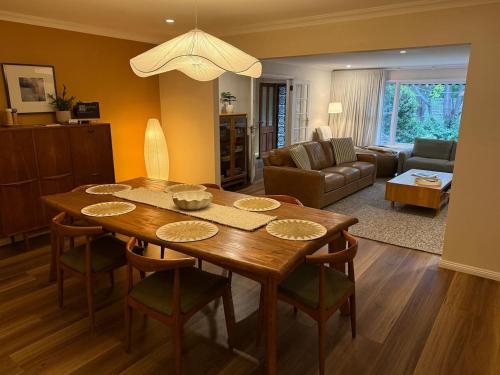 a living room with a wooden table and a dining room at Red Gum & Stone - Peace Space Nature in Warburton