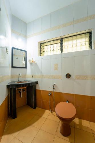 a bathroom with a toilet and a sink at Farmagudi Residency in Ponda