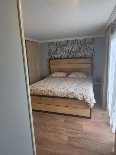 a bedroom with a bed with a wooden headboard at Het ooievaarsnest in Warmond