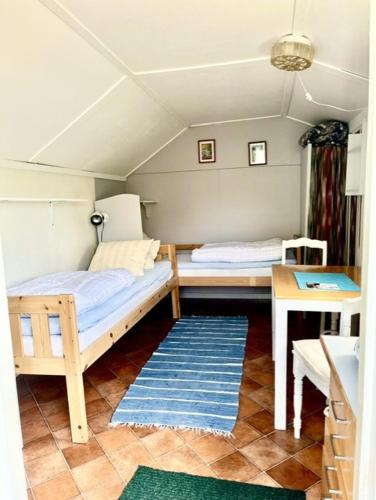 a room with a bed and a table in a room at Strandnära Stuga Saga in Visby