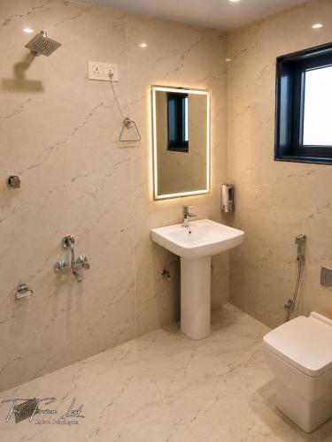 a bathroom with a sink and a toilet and a mirror at The Frozen Leaf in Pahalgām