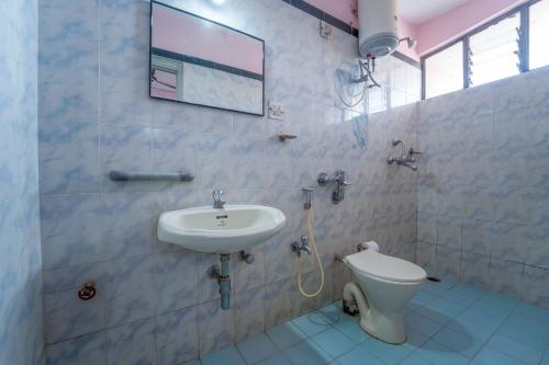 a bathroom with a sink and a toilet at Margao Residency in Madgaon