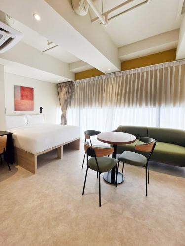 a hotel room with a bed and tables and chairs at Coliwoo Midtown - CoLiving in Singapore