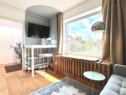 a living room with a large window and a couch at Apartment am Freitagsbach in Celle