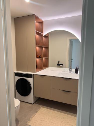 a bathroom with a sink and a washer and dryer at Mõisavälja apartment in Rakvere