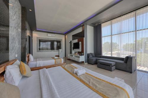 a large bedroom with two beds and a large window at Kelingking Sunset Point Hotel in Nusa Penida