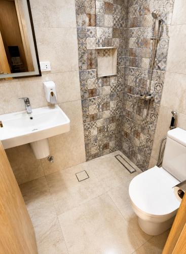 a bathroom with a toilet and a sink and a shower at Landmark Hostel Cairo in Cairo