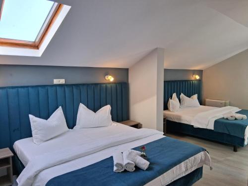 a hotel room with two beds with towels on them at ADMAR Rooms & Restaurant in Costinesti