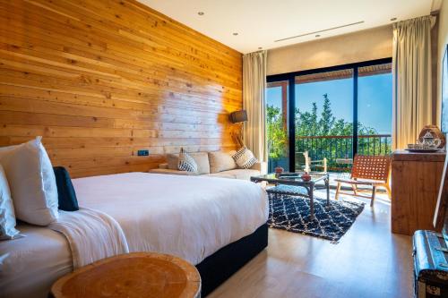 a bedroom with a bed and a wooden wall at Bio et Bois -Luxury Bio Farm- in Moulay Yacoub