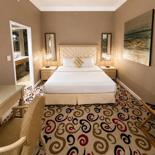 a bedroom with a large white bed and a chair at Silka Maytower Kuala Lumpur in Kuala Lumpur
