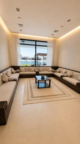 a living room with a large couch and a table at Paradise in Al Khīrān